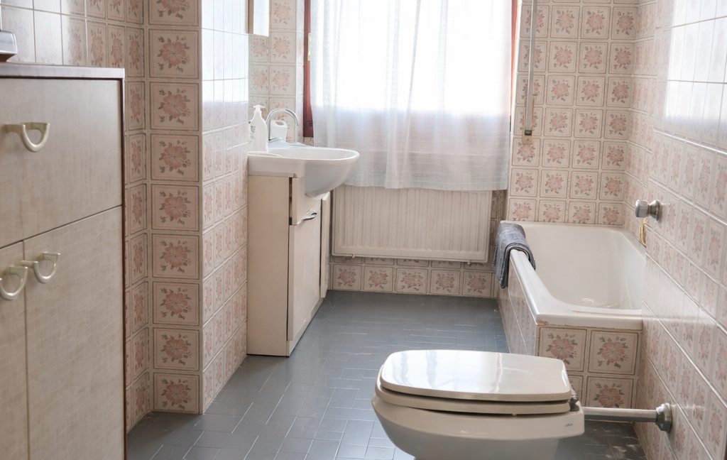 Bagno vintage con piastrelle floreali rosa